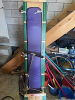 Full view of the toboggan with purple cushion pad and attached silver scooter, positioned in garage.