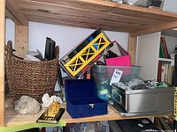 Shelf with woven basket, fossil rocks, blue display box, plastic bin with Lego pieces, metal storage bin