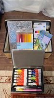 Photo showing the art supplies inside the basket including Prismacolor pencil crayons, oil pastels, and art journal