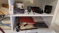 Overall view of shelf displaying the camera, accessories, manuals, and packaging box.