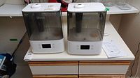 Two Levoit VeSync Classic 300S humidifiers on a counter, showing white base and dark translucent tanks.