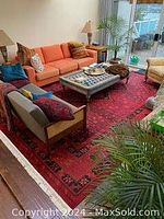 Full view of red area rug under living room furniture, showing pattern and size