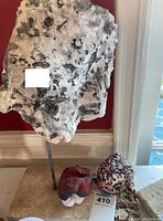 Front view of main bust sculpture on stone base with two small abstract pieces in front