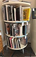 Front view of round three-tier bookcase loaded with books