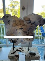 Front view of the abstract sculpture on stone base, showing textures and color patches