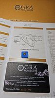 Top photo of GRA Moissanite certification card with gemstone photo and cutting proportions.