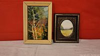 Both miniature oil paintings side by side against a red background showing frames and general condition.