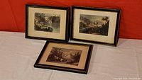 Three framed prints depicting the Rideau Canal scenes laid against a red background, showing overall lot contents and visible frame details.