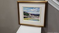 Full view of the framed oil painting depicting the Gatineau River landscape with blue sky, distant trees, and water reflections.
