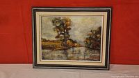 Frontal view of the framed oil painting depicting lake and trees scene.