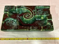 Top close-up view showing detailed swirl pattern and multiple recessed areas for cigarettes/cigars and ashes