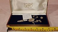 Full lot of sterling silver jewelry pieces photographed in an open box with blue lining and white satin lid showing all items in the lot