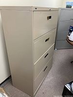 Side angle of beige 4 drawer filing cabinet, showing full height and drawer flush fronts with recessed handles