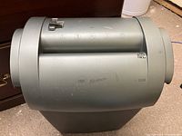 Side view of the GBC Shredmaster shredder showing the gray cylindrical body and brand markings.