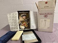 Full view of doll in original box with certificate and outer shipping box.