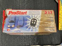 Photo of the worn and partially damaged box of ProStart 3-in-1 Automatic Car Starter with Remote Keyless Entry and built-in alarm system with product image and features indicated.