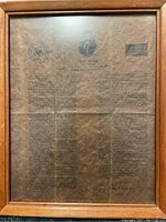 Framed parchment reproduction of JFK's Inaugural Address with US seal, JFK portrait, and American flag visible.