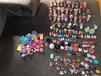 Overview of over 30 LOL Surprise dolls, many pet minis, and a large variety of accessories including multiple cups, hats, handbags, hairpieces, and small items.