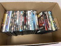 Box with 25 DVDs lined up showing a variety of genres and titles.