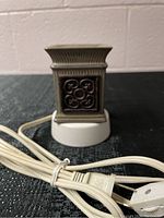 Mini Scentsy wax warmer showing side decorative ceramic design, attached white power cord and base.