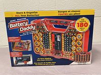 Box of Battery Daddy storage system showing product images and highlighting capacity of 180 batteries and built-in tester.