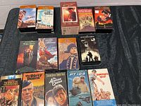 Eight factory sealed VHS tapes laid out on a surface showing front cover artwork for various classic movies