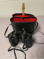 Carl Wetzlar binoculars with leather carrying case featuring red fabric interior and strap.