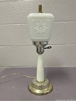 Full lamp showing tapered milk glass column, brass base, square floral embossed milk glass shade, and key switch