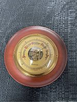 Overall view of the vintage Westclox barometer showing wooden frame, brass bezel, and face with weather indicators.