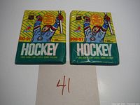 Two unopened 1990-91 OPC hockey wax packs with visible front designs showing hockey player and pack branding.