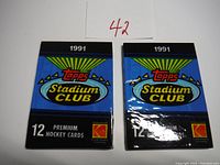 Two unopened 1991 Topps Stadium Club hockey card packs with blue and black packaging and Kodak logo.
