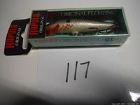 Photo of one silver and red Rapala Original Floating F-7 fishing lure in original clear plastic box with packaging and hang tag.