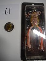 New unopened Croaker Frog fishing lure packaged with a coin for size reference