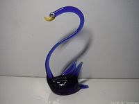Front view of cobalt blue glass swan figurine showing curved neck, beak, and wings.