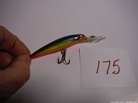 Photo of first Rapala X-Rap Deep fishing lure showing the side profile with metallic green, yellow, and orange color, and two treble hooks.