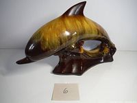 Side view of vintage Blue Mountain Pottery dolphin figurine showing amber and brown glaze and base detailing.