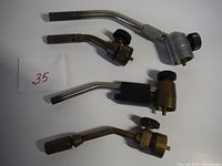 Photo of all four propane torch heads laid out showing variety in size, shape, and finish.