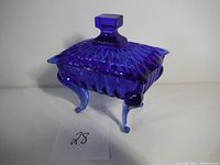 Full view of the cobalt blue glass candy dish with lid, showing the diamond textured pattern and curled feet.