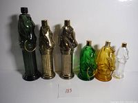 Five horse head glass decanters of different colors displayed together to show overall set and condition.