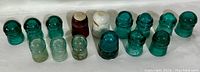 Full set of 18 antique insulators including aqua blue and clear glass insulators, and one porcelain insulator.
