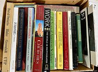 Top view of a box with multiple art and architecture books standing upright showing titles and colorful spines.