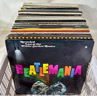 Front view of crate filled with vinyl records showing 'Beatlemania' album in front.