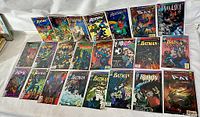 Wide view of 26 vintage DC comic books laid out showing various Batman stories and related characters.