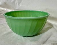 Side view of a green Jadeite mixing bowl showing ribbed swirl pattern and jade green color.