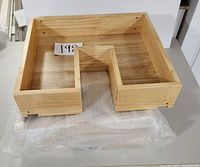 Top view of one wooden drawer box showing natural wood finish and U-shaped cutout for plumbing access.