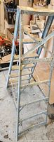 Side view of 6 foot aluminum ladder showing six rungs and folding mechanism.