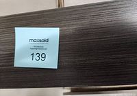 Close-up of the wood grain texture and color showing a dark black finish and a MaxSold auction tag