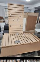 Two new melamine slatwall panels shown side by side and upright with metal display hooks inserted in some grooves. Panels are light wood color with evenly spaced horizontal slots.