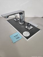 Front side view of TENZO SLICK SL13-CR widespread 3 hole lavatory faucet set on display board with MaxSold tag.