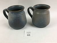 Two modernist coffee mugs side by side showing overall shape and color
